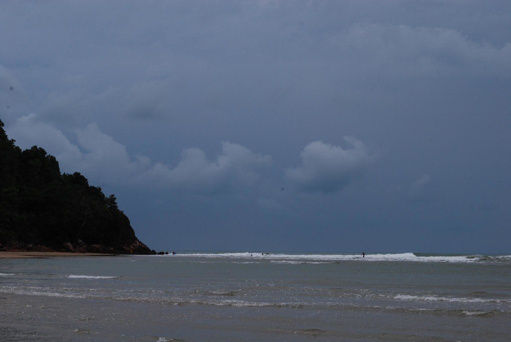 Surfers in the water at Cherating Beach